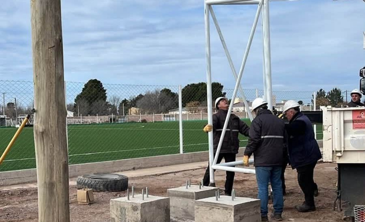 Montan torres de iluminación en cancha de césped sintético
